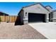 Attached two-car garage with concrete driveway and desert landscaping for easy maintenance at 11894 E Aster Ln, Florence, AZ 85132