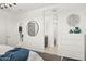 Bright bedroom with a view to the bathroom and kitchen, featuring a round mirror and chest of drawers at 11943 E Aster Ln, Florence, AZ 85132
