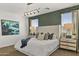 Charming bedroom with decorative green wall, plush bedding, and plenty of natural light from the windows at 11943 E Aster Ln, Florence, AZ 85132