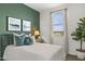 Comfortable bedroom featuring an green accent wall, plush bedding and a scenic view from the window at 11943 E Aster Ln, Florence, AZ 85132