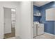 Bright laundry room with modern washer and dryer and a blue accent wall at 11943 E Aster Ln, Florence, AZ 85132
