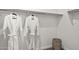Neat walk-in closet featuring two white bathrobes hanging on a rod and woven basket for storage at 11943 E Aster Ln, Florence, AZ 85132