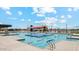 Expansive community pool area featuring multiple pools, a splash pad, and lounge chairs for relaxation at 11959 E Aster Ln, Florence, AZ 85132
