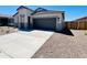 Single-story house shows a modern elevation, smooth concrete driveway, well-kept desert landscape, and a two-car garage at 11959 E Aster Ln, Florence, AZ 85132
