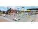 Community splash pad with colorful play features and lounge chairs for relaxing poolside on a sunny day at 11959 E Aster Ln, Florence, AZ 85132