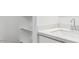 Bright bathroom featuring a pristine white countertop, sink, and convenient shelving at 12443 E Bahia Ct, Florence, AZ 85132