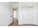 Bright bedroom features wood-look floors, sliding door closet, and doorway to hall at 12443 E Bahia Ct, Florence, AZ 85132