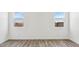 Minimalist bedroom with wood-look floors and dual windows providing natural light at 12443 E Bahia Ct, Florence, AZ 85132