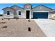 A charming single-story home boasting a well-maintained yard and a modern blue garage door at 12443 E Bahia Ct, Florence, AZ 85132