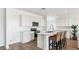 Modern kitchen with an island with barstool seating, white cabinets, and stainless steel appliances at 12443 E Bahia Ct, Florence, AZ 85132