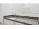 A bathroom featuring a sink and granite countertop, with a mirror reflecting the shower at 12456 E Bahia Ct, Florence, AZ 85132