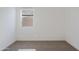 A well-lit bedroom featuring neutral carpet, white walls, and a window at 12456 E Bahia Ct, Florence, AZ 85132