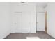 Sunlit bedroom with white walls and carpet featuring a closet with sliding doors and an open door at 12456 E Bahia Ct, Florence, AZ 85132