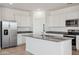 Open concept kitchen with white cabinetry, stainless steel appliances, and a central island with a sink at 12456 E Bahia Ct, Florence, AZ 85132