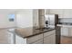 Granite island in kitchen with stainless steel sink, dishwasher and adjacent stainless steel refrigerator at 12456 E Bahia Ct, Florence, AZ 85132
