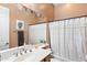 Cozy bathroom features a vanity with a large mirror, a shower curtain and a plant at 12493 S 179Th Ln, Goodyear, AZ 85338