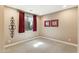 Neutral-toned room featuring a large window adorned with red drapes, creating a bright and inviting space at 12493 S 179Th Ln, Goodyear, AZ 85338