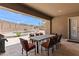 Covered outdoor dining area with a large table and chairs overlooking a fenced pool area, great for entertaining at 12493 S 179Th Ln, Goodyear, AZ 85338