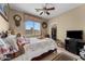 A cozy bedroom with natural light, ceiling fan, and vintage furniture and decor at 14694 W Mandalay Ln, Surprise, AZ 85379