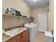A functional laundry room with side by side washer and dryer and storage at 14694 W Mandalay Ln, Surprise, AZ 85379