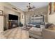 Cozy living room featuring a fireplace, comfortable sectional sofa, and a ceiling fan for added comfort at 14694 W Mandalay Ln, Surprise, AZ 85379