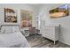 Bright bedroom featuring gray wood floors, a TV, desk, and comfortable furnishings at 15691 N 104Th Pl, Scottsdale, AZ 85255
