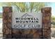 Stone sign for McDowell Mountain Golf Club in a community with desert landscaping and bright sunny skies at 15691 N 104Th Pl, Scottsdale, AZ 85255