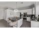 Kitchen featuring white cabinets, stainless steel appliances, island with seating, and modern lighting at 15691 N 104Th Pl, Scottsdale, AZ 85255