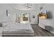 Bright main bedroom with a ceiling fan, TV, ensuite access, and an oversized window with a backyard view at 15691 N 104Th Pl, Scottsdale, AZ 85255