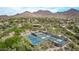 Aerial view of a community featuring tennis and pickleball courts nestled within a desert landscape with mountain views at 15691 N 104Th Pl, Scottsdale, AZ 85255