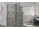 Modern shower with grey textured tile, a river stone accent wall, and glass accents at 15691 N 104Th Pl, Scottsdale, AZ 85255