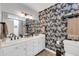 This bathroom has dual sinks, a vanity, designer wallpaper, and a shower-tub at 1607 E Gable Ave, Mesa, AZ 85204
