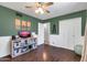 A bedroom featuring a ceiling fan, wainscotting, and a large closet with bi-fold doors at 1607 E Gable Ave, Mesa, AZ 85204