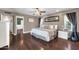 The main bedroom has a ceiling fan, a framed mirror above the bed, and dark wood floors at 1607 E Gable Ave, Mesa, AZ 85204