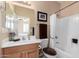 Bathroom featuring vanity with wood cabinets, white countertop, mirror, and a tub-shower combo at 17613 W Gelding Dr, Surprise, AZ 85388