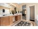 Spacious bathroom featuring dual sinks, a makeup vanity, and access to the soaking tub and shower at 17613 W Gelding Dr, Surprise, AZ 85388