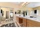 Well-lit bathroom features dual sinks, plenty of cabinet space, and access to the closet at 17613 W Gelding Dr, Surprise, AZ 85388