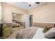 Bedroom with mirrored closet doors reflecting the bed, ceiling fan, and bedside tables at 17613 W Gelding Dr, Surprise, AZ 85388