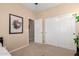 Neutral bedroom showing an open door and closet, complemented by a framed contemporary art piece at 17613 W Gelding Dr, Surprise, AZ 85388