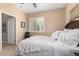 Comfortable bedroom showcasing a fluffy white bed, a shuttered window, and decorative wall art at 17613 W Gelding Dr, Surprise, AZ 85388
