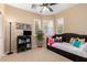 Bright bedroom featuring a cozy daybed, neutral walls, and natural light from shuttered windows at 17613 W Gelding Dr, Surprise, AZ 85388