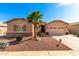 Charming home featuring stone accents, a desert landscape, and a well-manicured lawn at 17613 W Gelding Dr, Surprise, AZ 85388