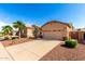 Beautiful single-story home with desert landscaping, a two-car garage, and mature palm trees at 17613 W Gelding Dr, Surprise, AZ 85388