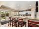 Bright kitchen features granite counters, white cabinets and an island with barstool seating and outdoor patio access at 17613 W Gelding Dr, Surprise, AZ 85388