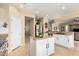 Bright kitchen has an island with sink, granite countertops, modern stainless appliances, and white cabinets at 17613 W Gelding Dr, Surprise, AZ 85388