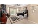 Spacious main bedroom featuring cozy carpet, dark wood furniture and backyard pool view at 17613 W Gelding Dr, Surprise, AZ 85388