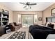 Inviting main bedroom with ceiling fan, chair, and sliding glass doors that lead to the backyard pool at 17613 W Gelding Dr, Surprise, AZ 85388