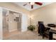 Office with carpeted floor and plant life, leads to the hallway with decorative tile at 17613 W Gelding Dr, Surprise, AZ 85388
