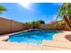 Refreshing backyard pool with a baja shelf, rock waterfall feature, and desert landscaping at 17613 W Gelding Dr, Surprise, AZ 85388