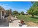 Expansive backyard featuring a well-maintained lawn and a cozy patio seating area perfect for relaxing and entertaining at 19046 N Signal Butte Cir, Sun City, AZ 85373